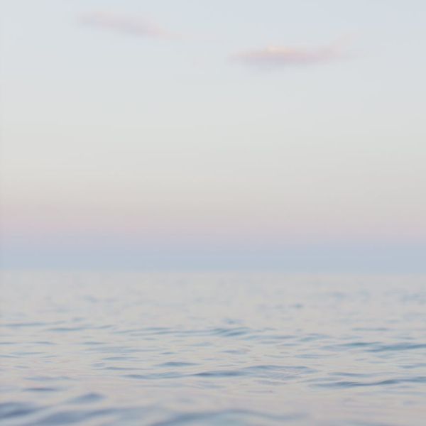 Serene woman meditating in a calm, minimalist environment.